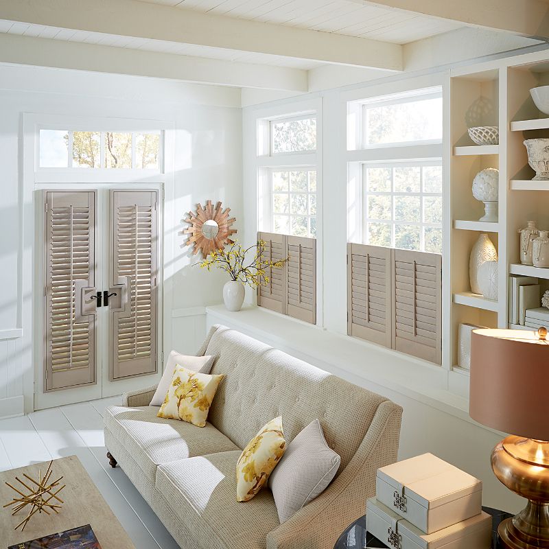 natural wood shutters on bottom half of windows in a living room